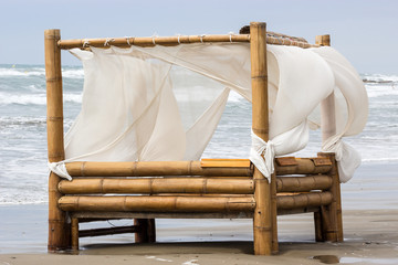 Obraz na płótnie Canvas lit en bambou avec des voiles blanches posé au bord de la plage