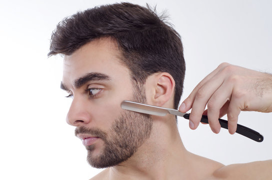 Closeup of man shaving with sharp razor, side view