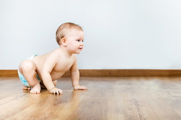 Naklejka premium Cute smiling baby sitting at home.
