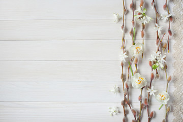 Light wood background with willow branches and spring flowers © tachinskamarina