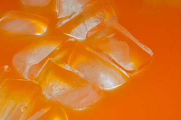 Close up of orange soda pop and ice cubes