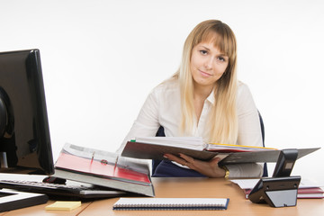 Office a specialist wearily leafing through a folder with documents