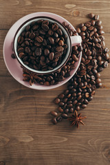 Cup of coffee beans on a wooden background