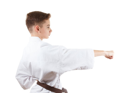 young karate boy in white kimono with brown belt