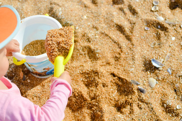 Child playing on the beach with sand