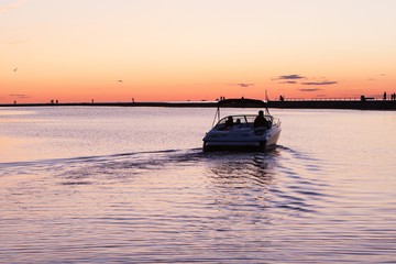 Motorboat driving to port in beautiful sunset