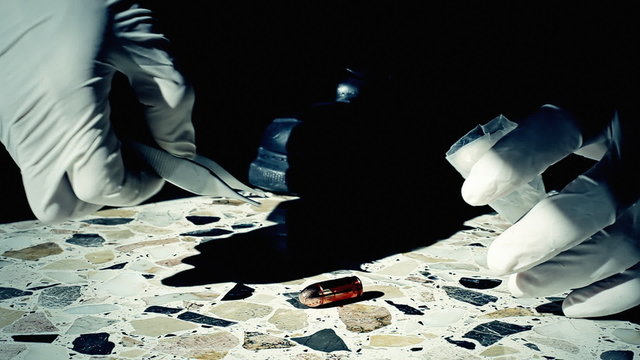Collecting a bullet soaked in blood from a crime scene with pliers and storing it in a plastic bag. Harsh sunlight, stark contrast.
