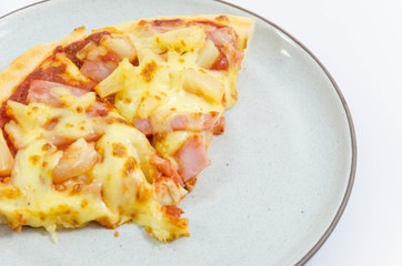 Slice of pineapple and ham pizzas on the plate
