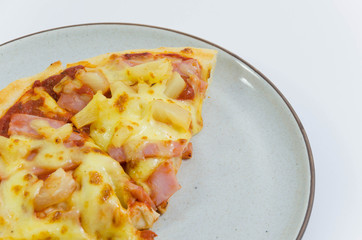 Slice of pineapple and ham pizzas on the plate