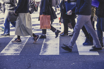 Fototapeta na wymiar 横断歩道を渡る人々の足,雑踏,横から撮影