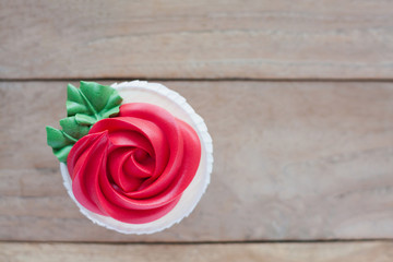 red rose cupcake on wooden table