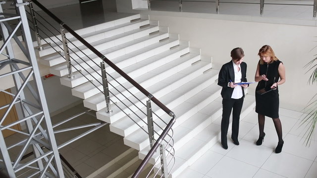 Two businesswomen discussing a contract. go around the office