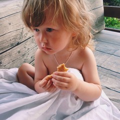 ребенок сидит и кушает на улице