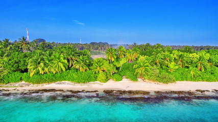 Shoreline of a tropical island in the Maldives and view of the I