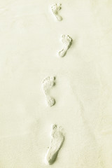 Traces of bare feet in the sand on a tropical island, Maldives.