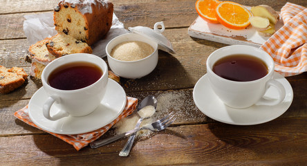 Cups of tea with sweet cake and ginger