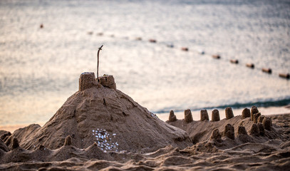 Sandburg am Strand im pastellfarbenen Sonnenaufgang