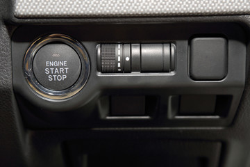 close up of engine start switch and multiple function control by button in sport car.