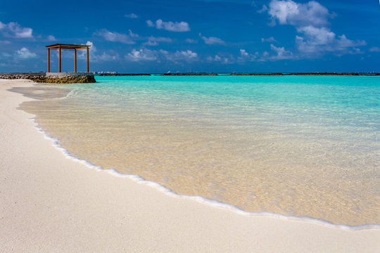 Closeup of water at Maldives with a gazebo in the background