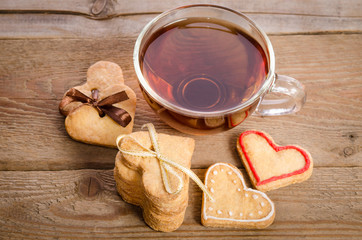 Cookies-hearts related together and a cup of tea on  wooden tabl