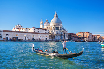 Fototapeta premium Canal Grande i Bazylika Santa Maria della Salute z gondolierem w Wenecji, Włochy