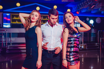 Beautiful girls and man having fun at a party in nightclub