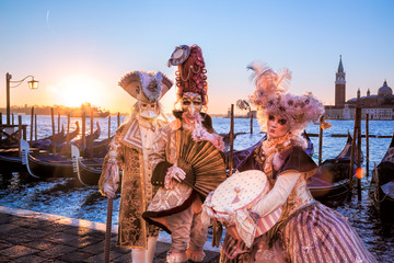 Carnival masks against sunrise in Venice, Italy