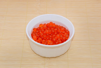 Bowl with caviar on bamboo mat