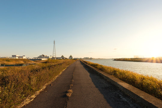 Road along a river at sunset time.