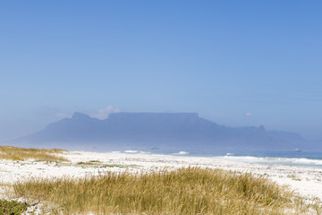 Sunny day at the white sand beach in South Africa. Cape Town and Table Mountain in the background.
