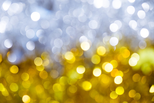 Gold half silver glitter sparkle defocused rays lights bokeh abstract chistmas background.
