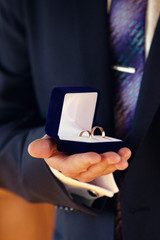 wedding rings in hands at the groom