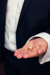 wedding rings in hands at the groom