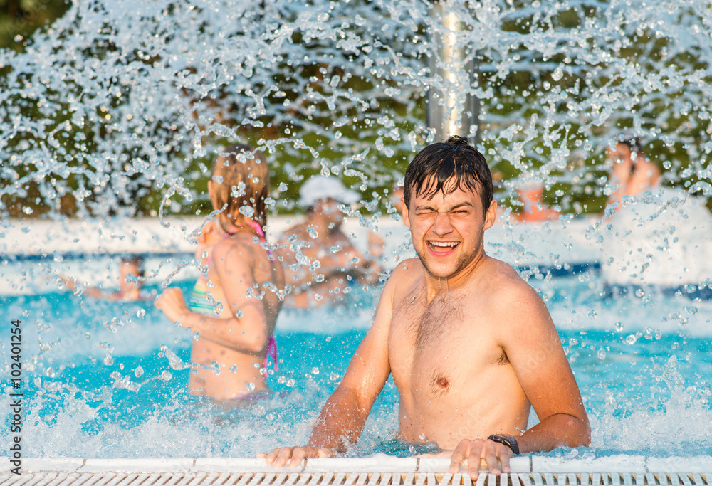 Canvas Prints couple in swimmning pool under splashing fountain. summer heat.