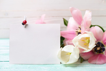 Postcard with fresh spring flowers and empty tag for your text o