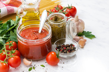 Fototapeta na wymiar tomato sauce, pesto and ingredients for pasta 