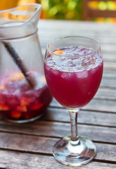 Glass of sangria on a wooden table.