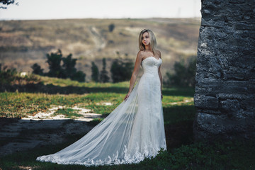 Beautiful stylsh blonde bride posing near old castle wall © IVASHstudio
