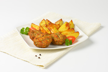 dish of vegetable and cheese patties with potato wedges