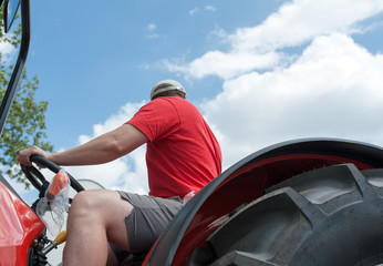 Young repairman ( farmer )  repairs tractor