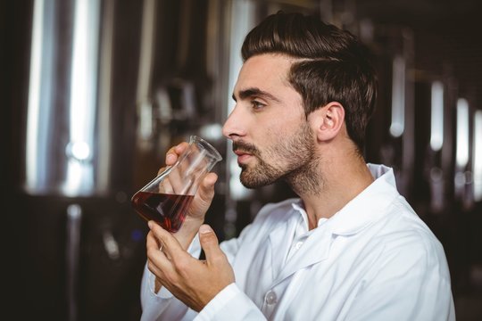 Brewer Smelling Beaker Of Beer