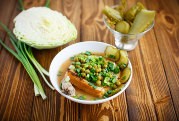 Puree soup with green peas, pickled cucumbers and croutons