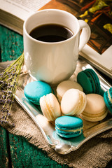 fresh macaroons and tea cup on wooden table .Vintage filter