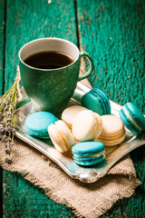 fresh macaroons and tea cup on wooden table .Vintage filter