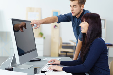 kollegen schauen gemeinsam auf computer