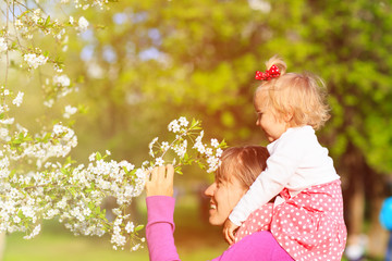mother and little daughter enjoy spring blossom