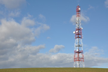Telecommunication tower against cloudy sky