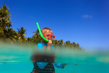 cute boy swimming and snorkeling in ocean