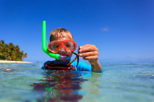little boy snorking at the beach