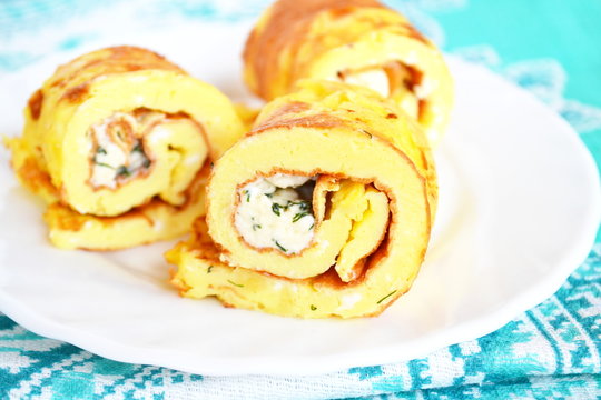 Rolls of omelette with cheese on a plate